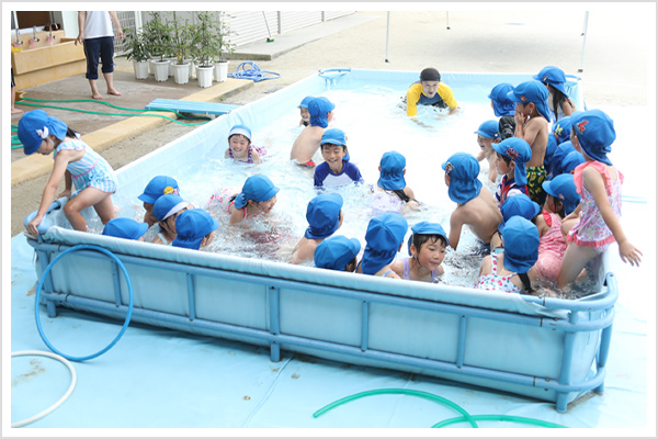 夏には園庭にプールを広げて水遊び